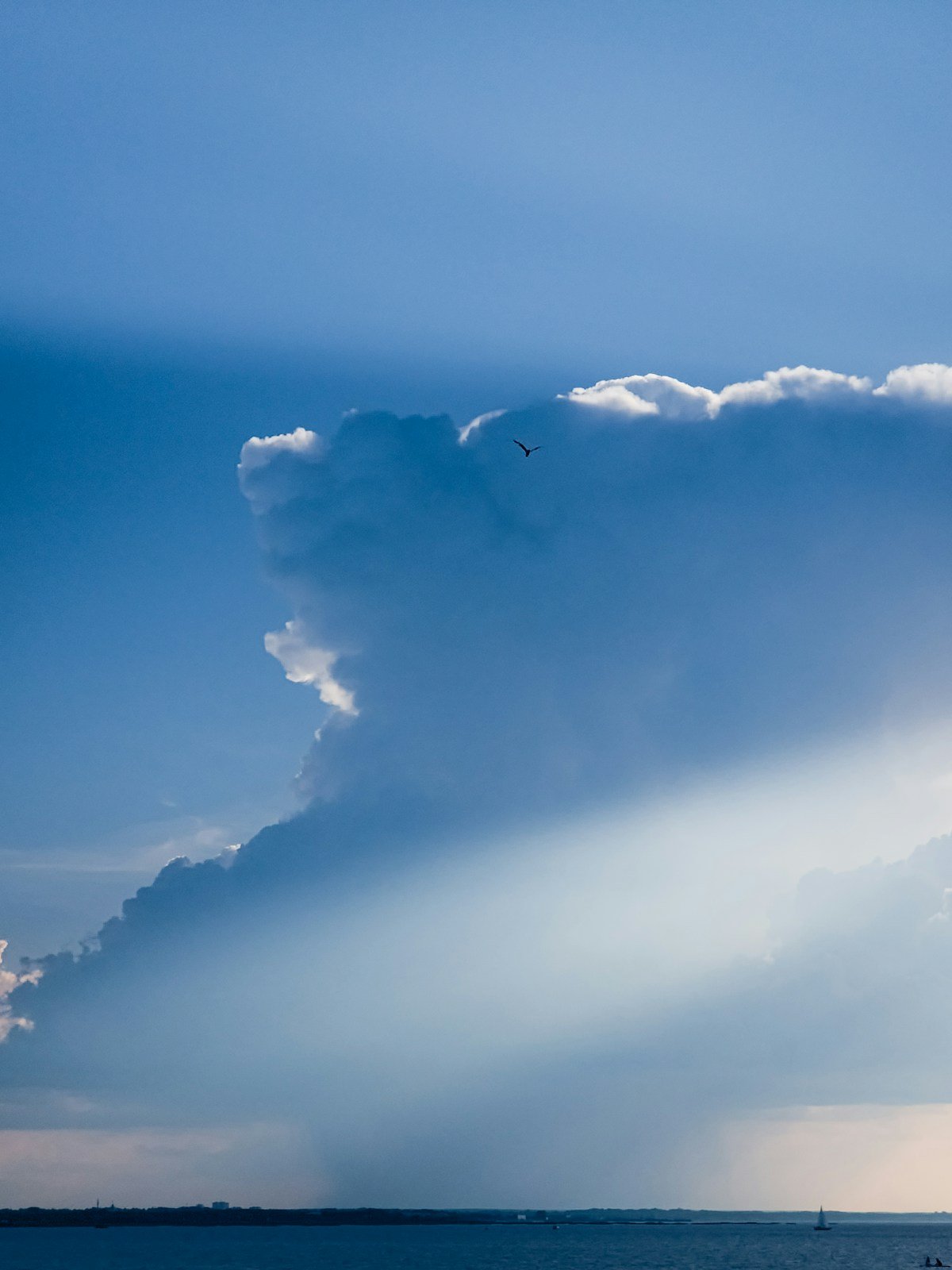 Dramatic clouds and sun rays over a distant horizon
