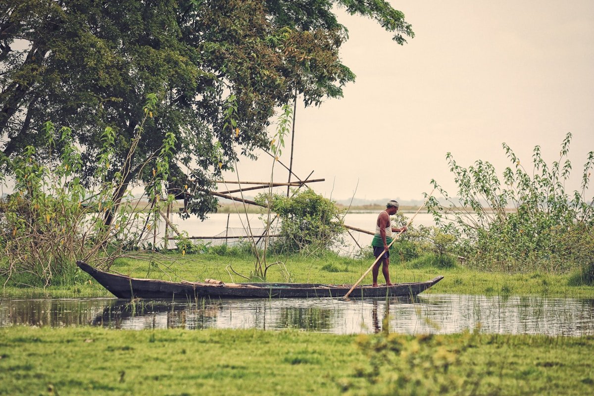 Fisherman navigating boat on Brahmaputra River Assam