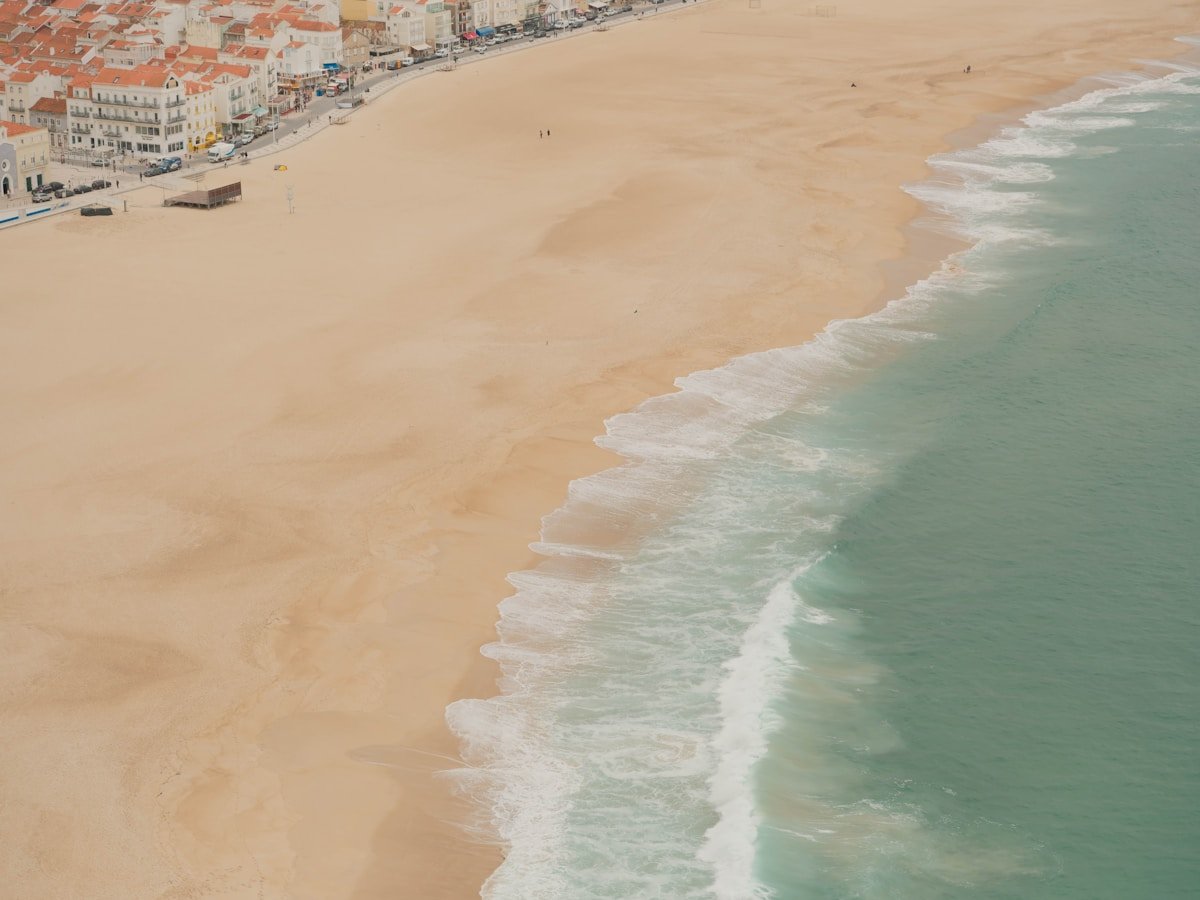 Sandy beach with ocean waves and coastal town