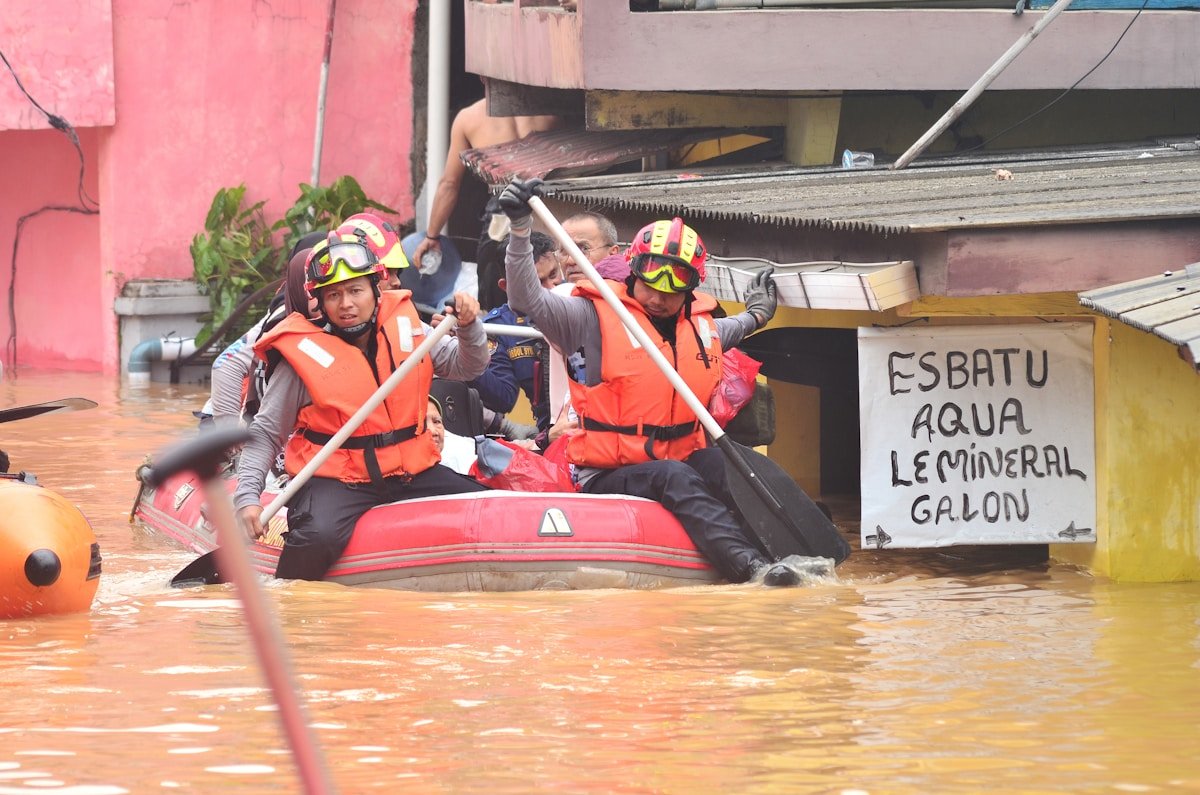 Rescue workers navigate floodwaters in an inflatable boat during flood disaster