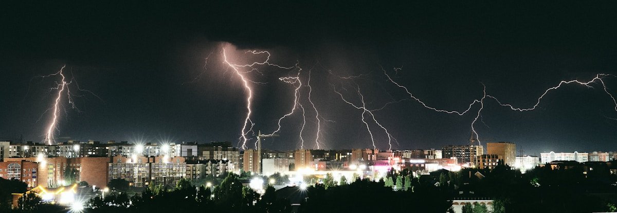Multiple lightning bolts illuminate a dark stormy sky
