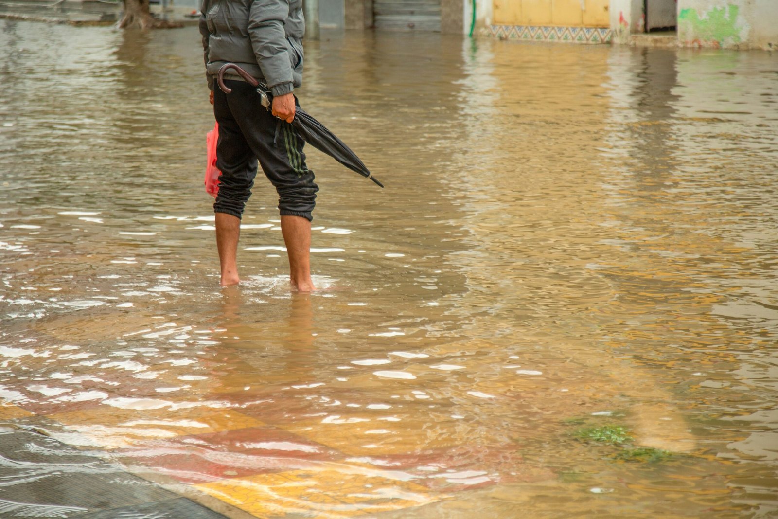 A man wades through flood waters on a street after heavy monsoon rain