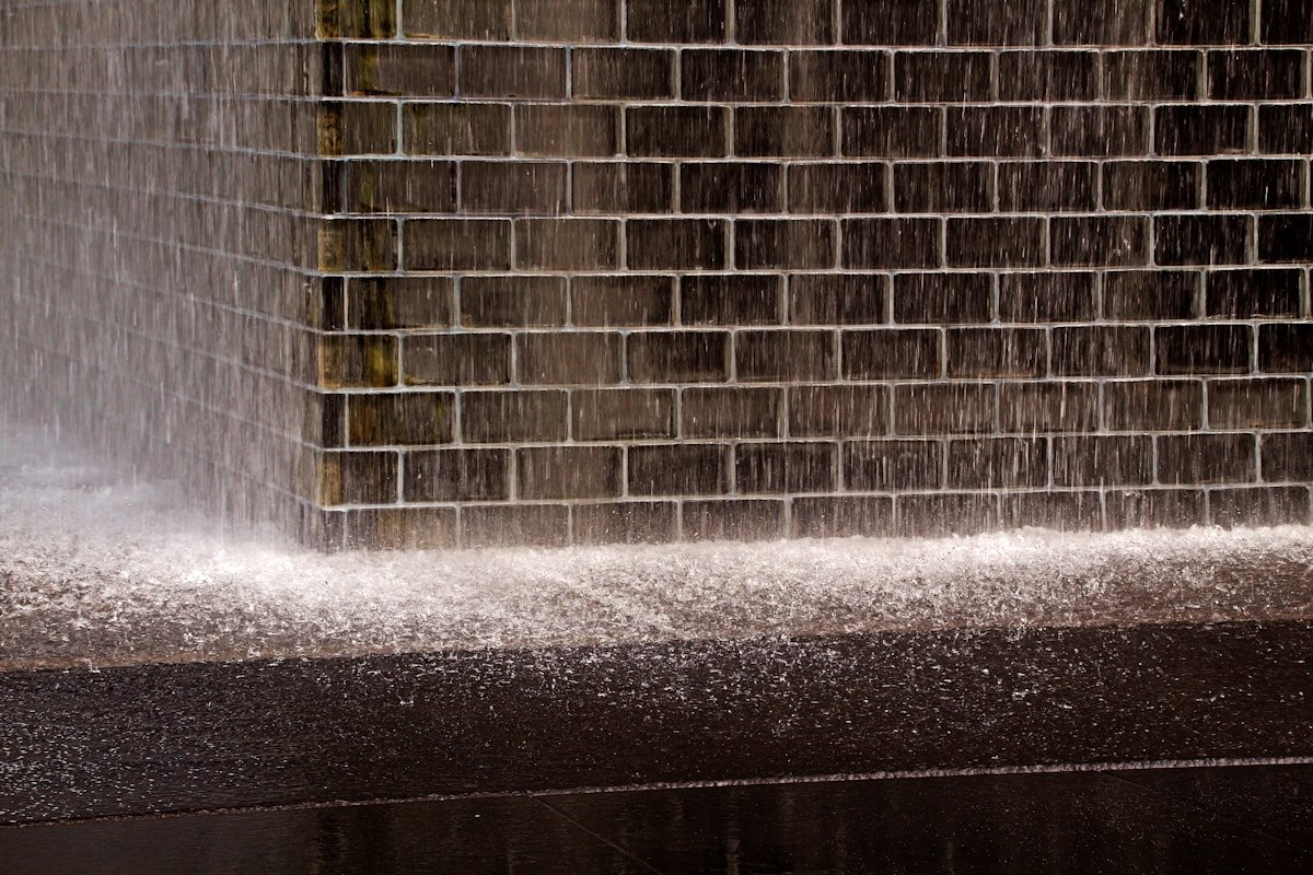 Water cascading down a building wall during intense monsoon rainfall